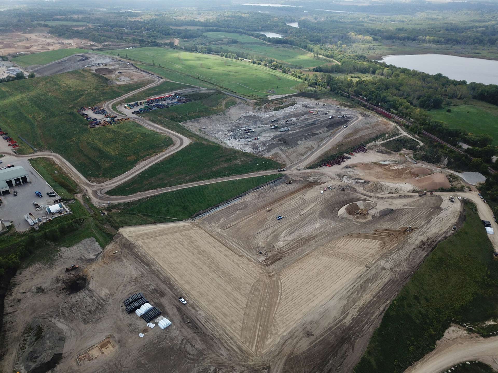 Aerial view of the landfill, with water in forest on horizon